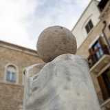 ...ed � costituito da una colonna in marmo bianco sormontata da una sfera...